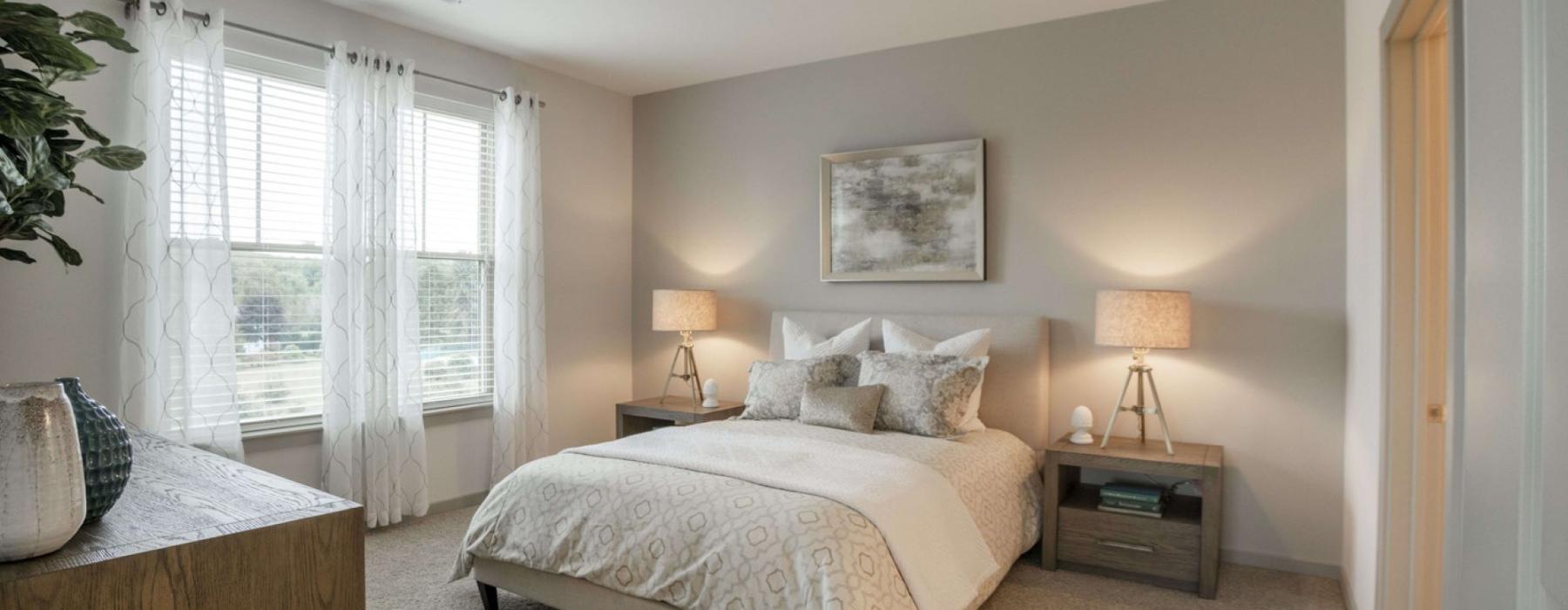 a bedroom with a bed and lamps