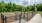 a fenced in area with a walkway and trees in the background