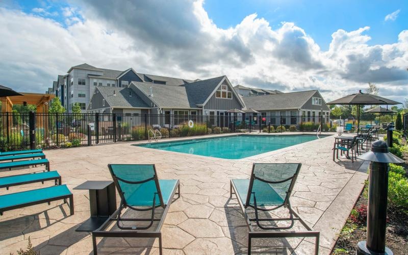 a pool and chairs on a patio